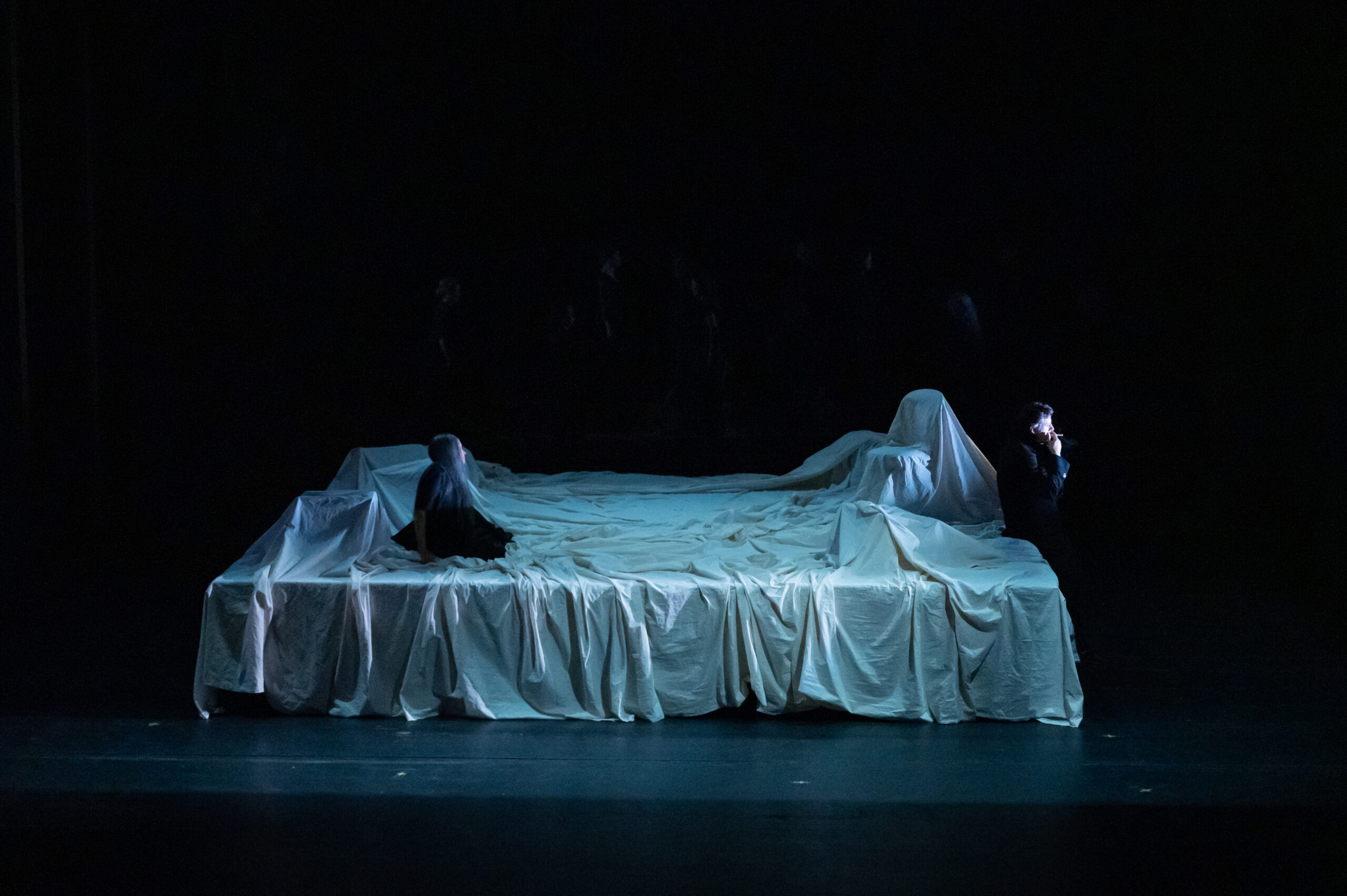 Bühnenbild und Kostüm von Lisa Behensky für La Bohème – Figur in weißem Stoff auf abstrahierter Spielfläche im dunklen Raum