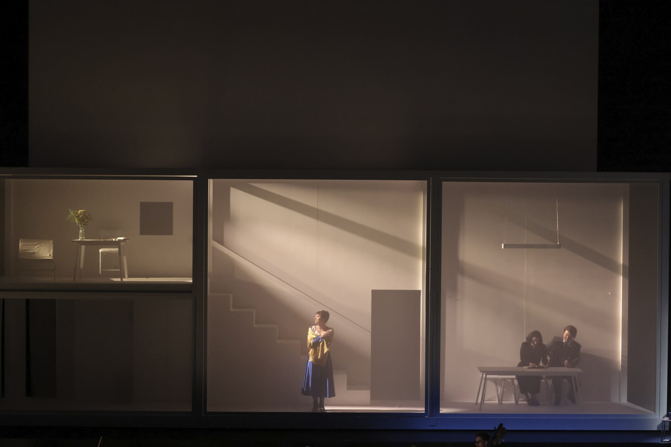 Szenografie von Lisa Behensky für Anna A. – fragmentierter Bühnenraum mit Treppe, mehreren Figuren und weichem Lichteinfall 