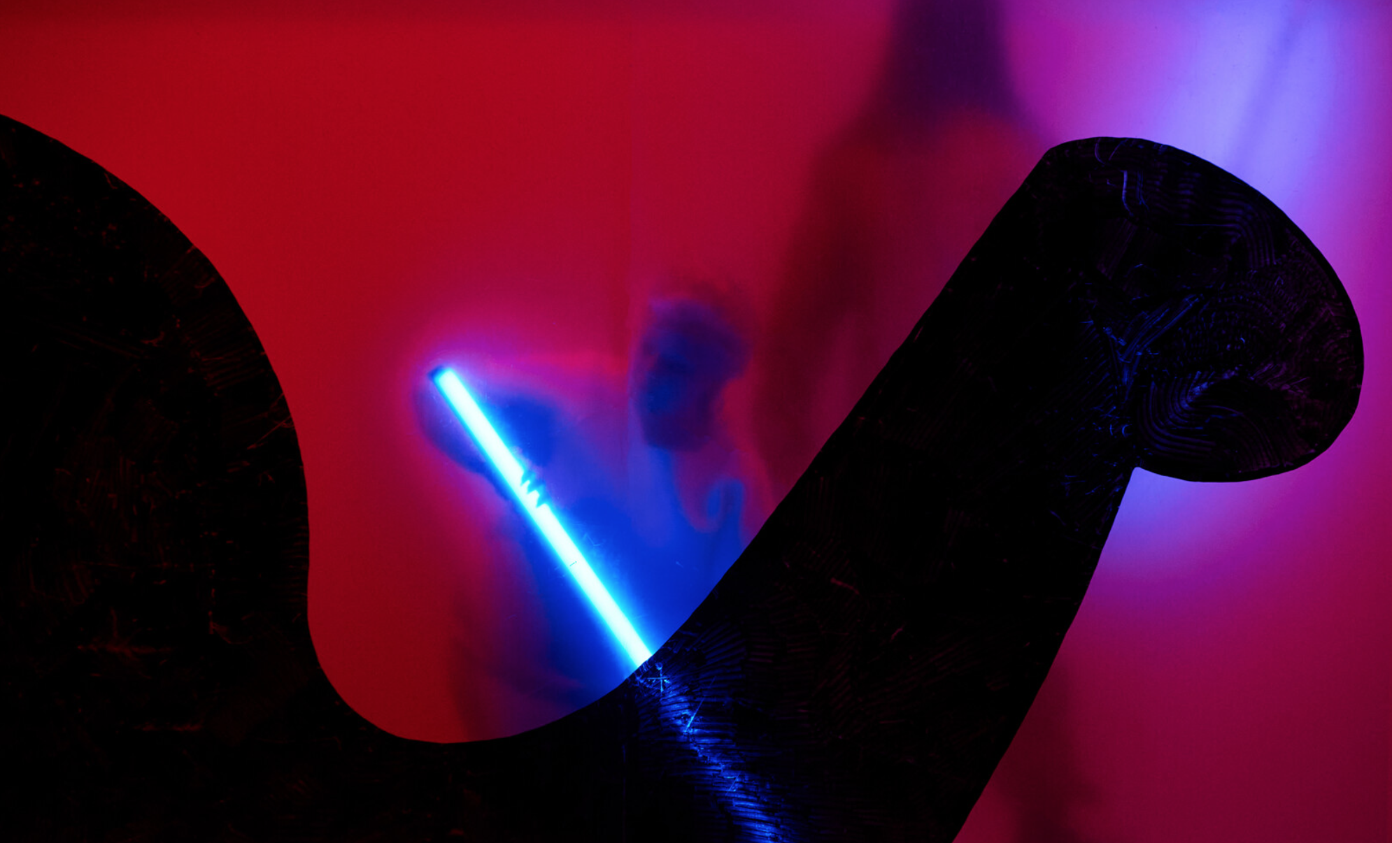 Szenografie und Kostüm von Lisa Behensky für ICARO – silhouettierte Figur hinter roter semitransparenter Membran mit blauem Lichtstab und organischer schwarzer Form im Vordergrund