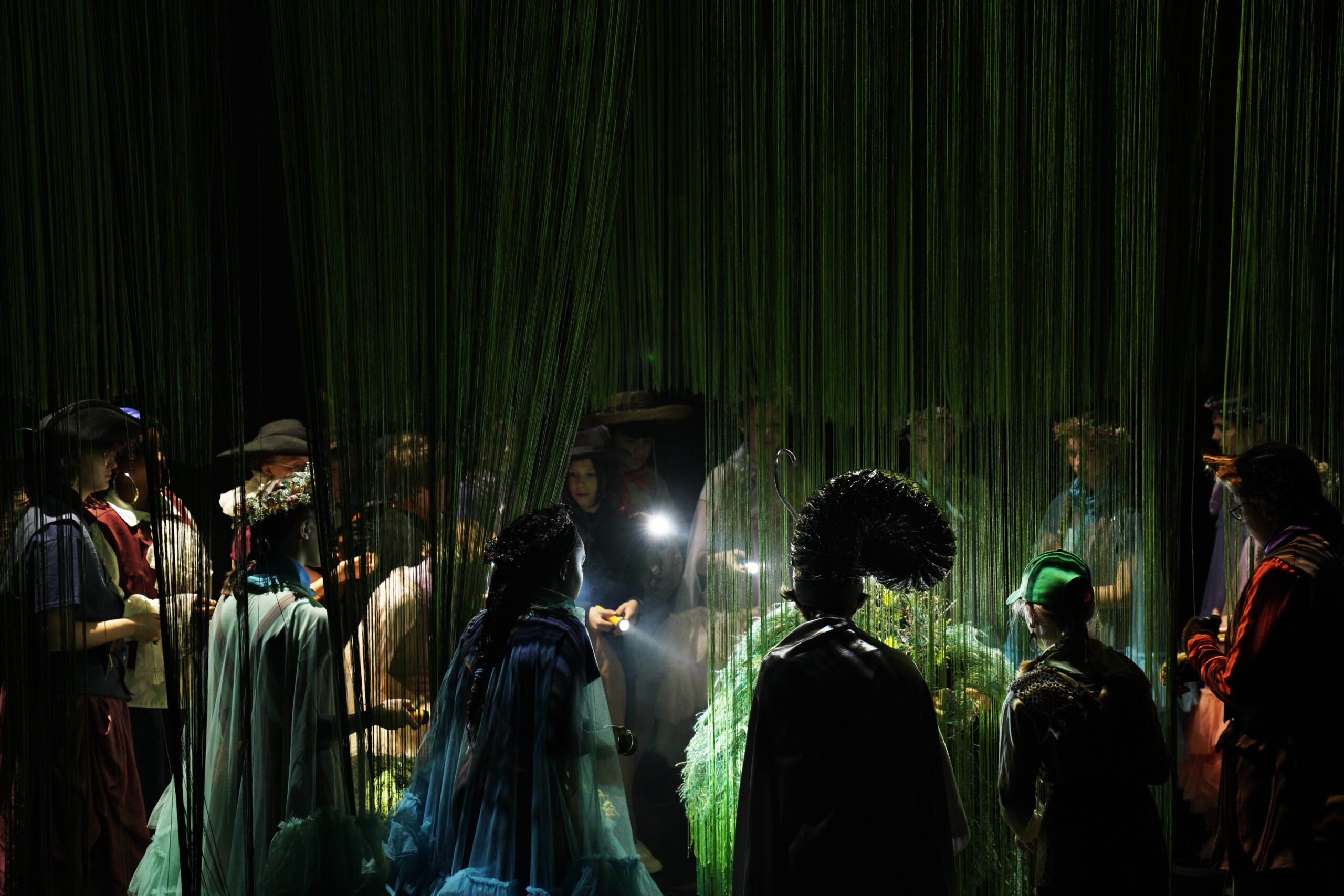 Szenografie und Kostüm von Lisa Behensky für Oberon / Träume – Gruppe von Figuren im Fadenraum um zentrale Traumfigur mit Taschenlampen 