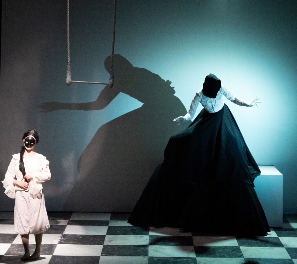 Szenografie und Kostüm von Lisa Behensky für Penelope – schwarze Figur im Schachbrett-Bühnenbild mit starken Schatten